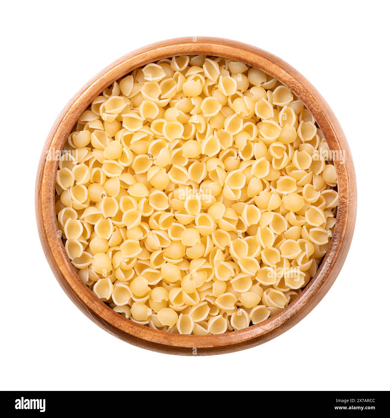 Perline o conchiglie, pastina e zuppa italiana in una ciotola di legno. Pasta minuscola, rotonda, a forma di guscio, di semola di grano duro cruda. Foto Stock