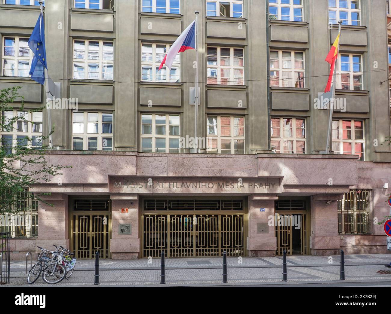 Praga, Repubblica Ceca - 10 maggio 2024: Un edificio governativo di Praga mostra più bandiere, tra cui la bandiera nazionale ceca, fuori dalla sua entrata Foto Stock