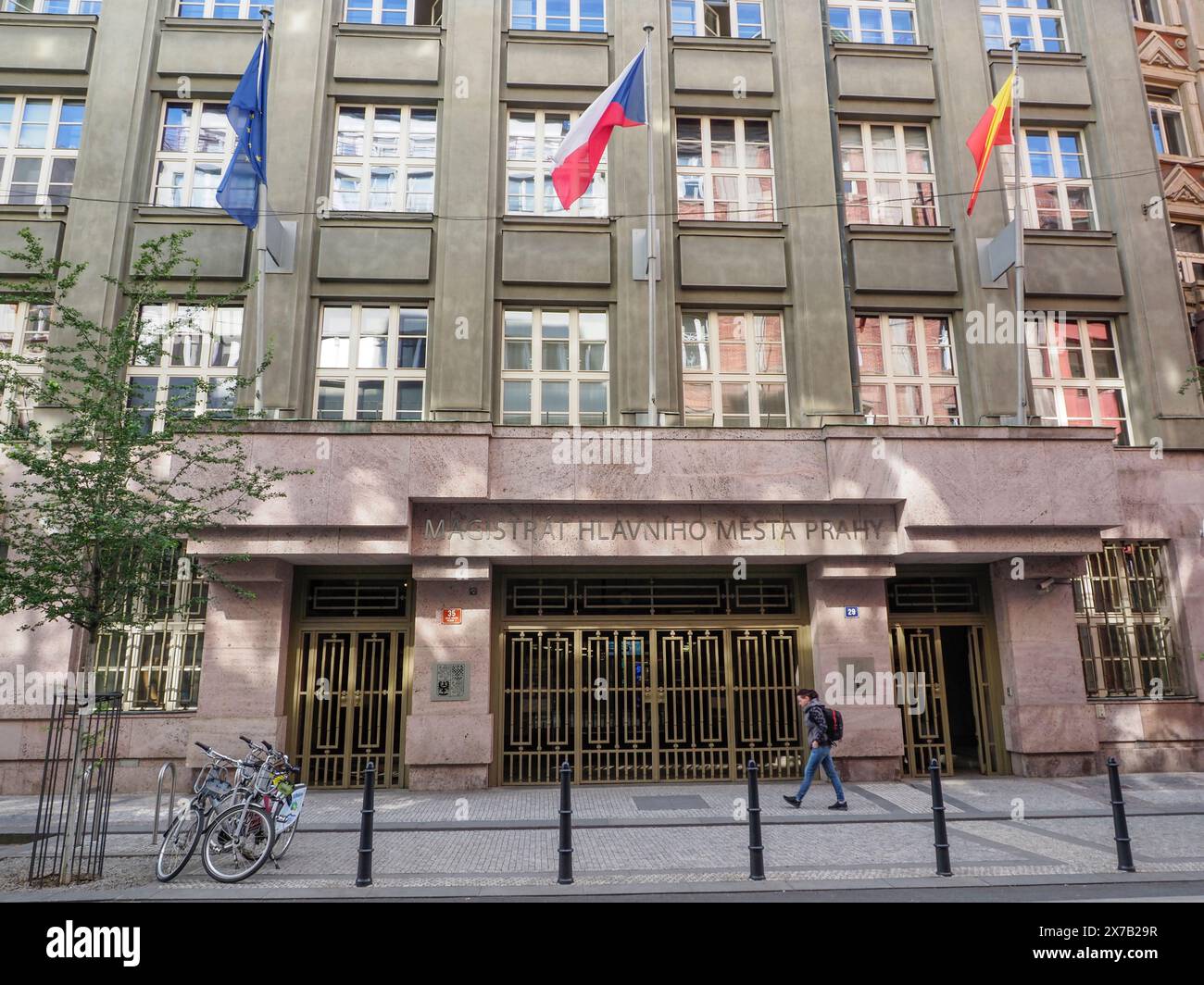 Praga, Repubblica Ceca - 10 maggio 2024: Un edificio governativo di Praga mostra più bandiere, tra cui la bandiera nazionale ceca, fuori dalla sua entrata Foto Stock
