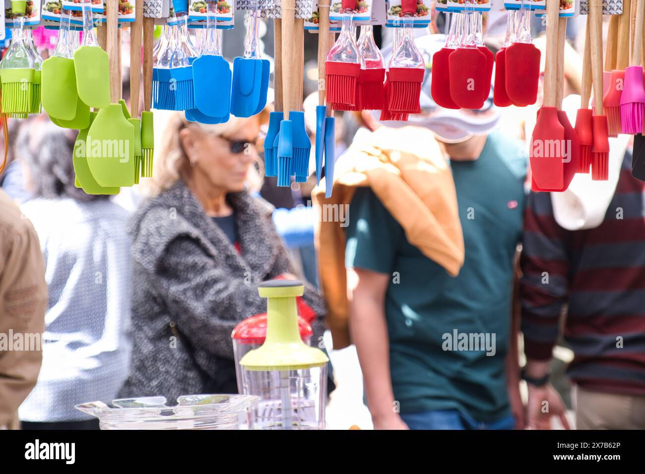 Vista delle persone sfocate dietro i prodotti di El Rastro, mercato all'aperto domenicale di Madrid Foto Stock