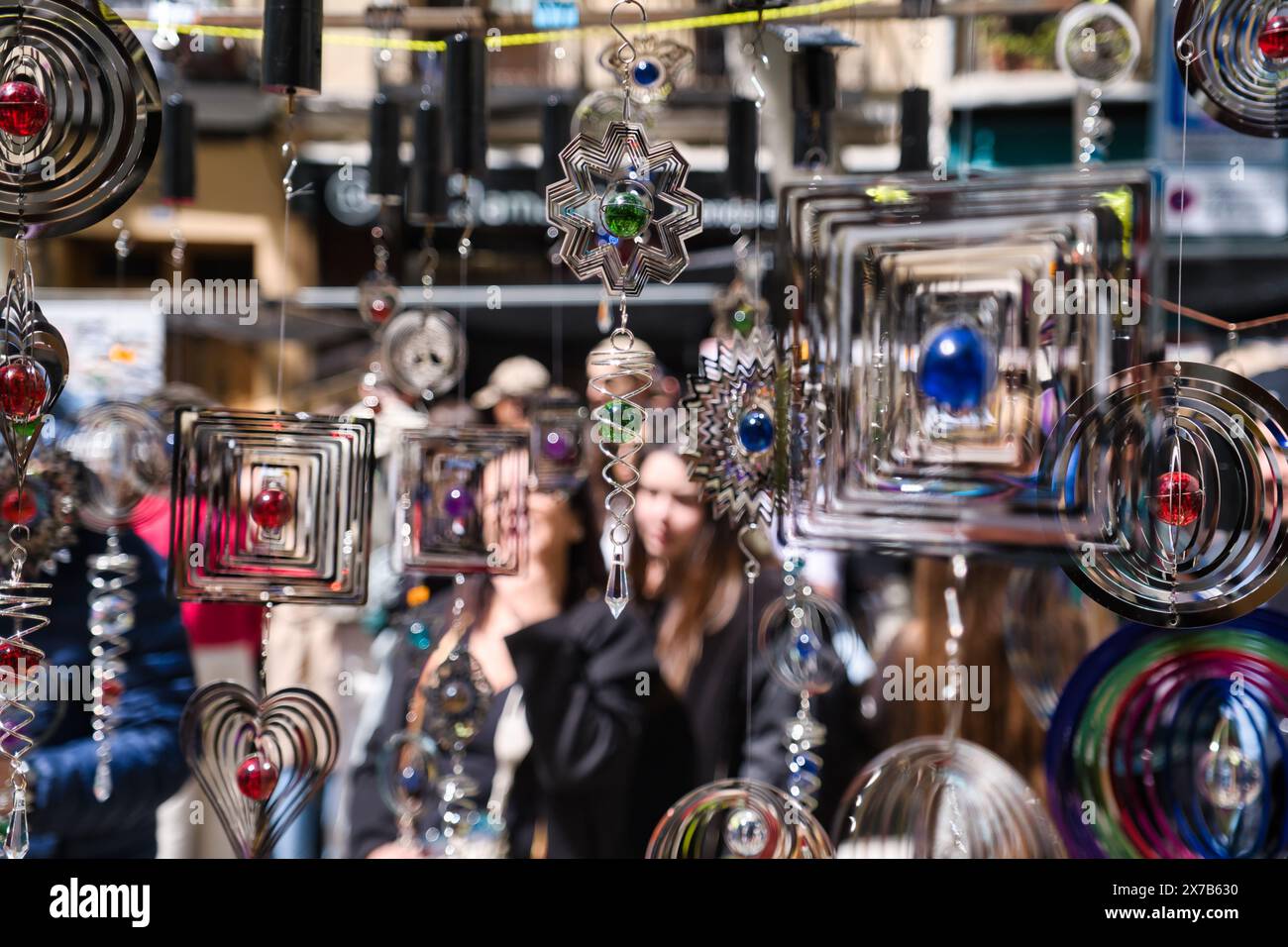Vista delle persone sfocate dietro i prodotti di El Rastro, mercato all'aperto domenicale di Madrid Foto Stock