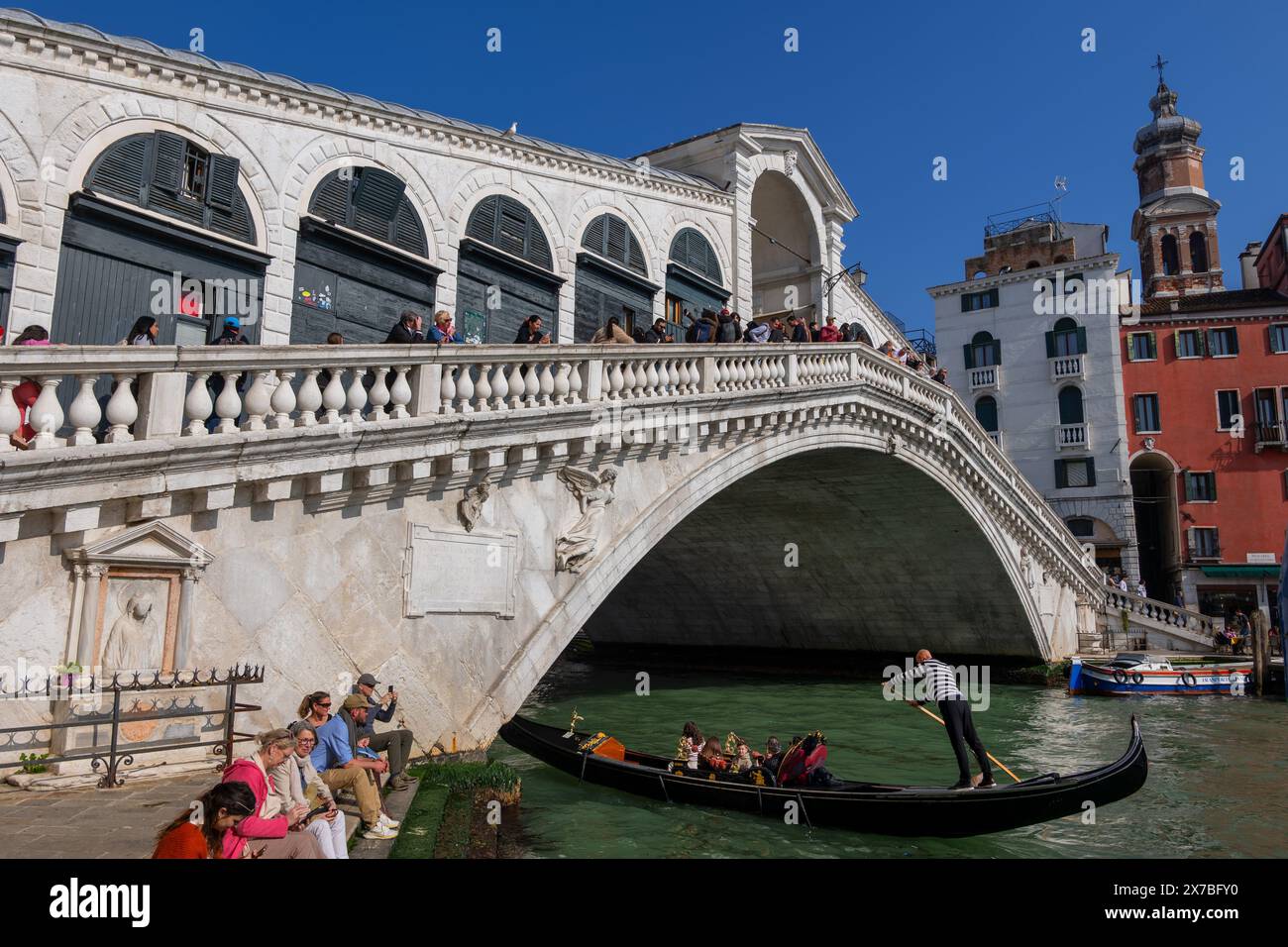 Il Ponte di Rialto sul Canal grande nella città di Venezia, Italia. La gondola passa sotto il ponte pedonale ad arco di pietra del XVI secolo che collega dis Foto Stock