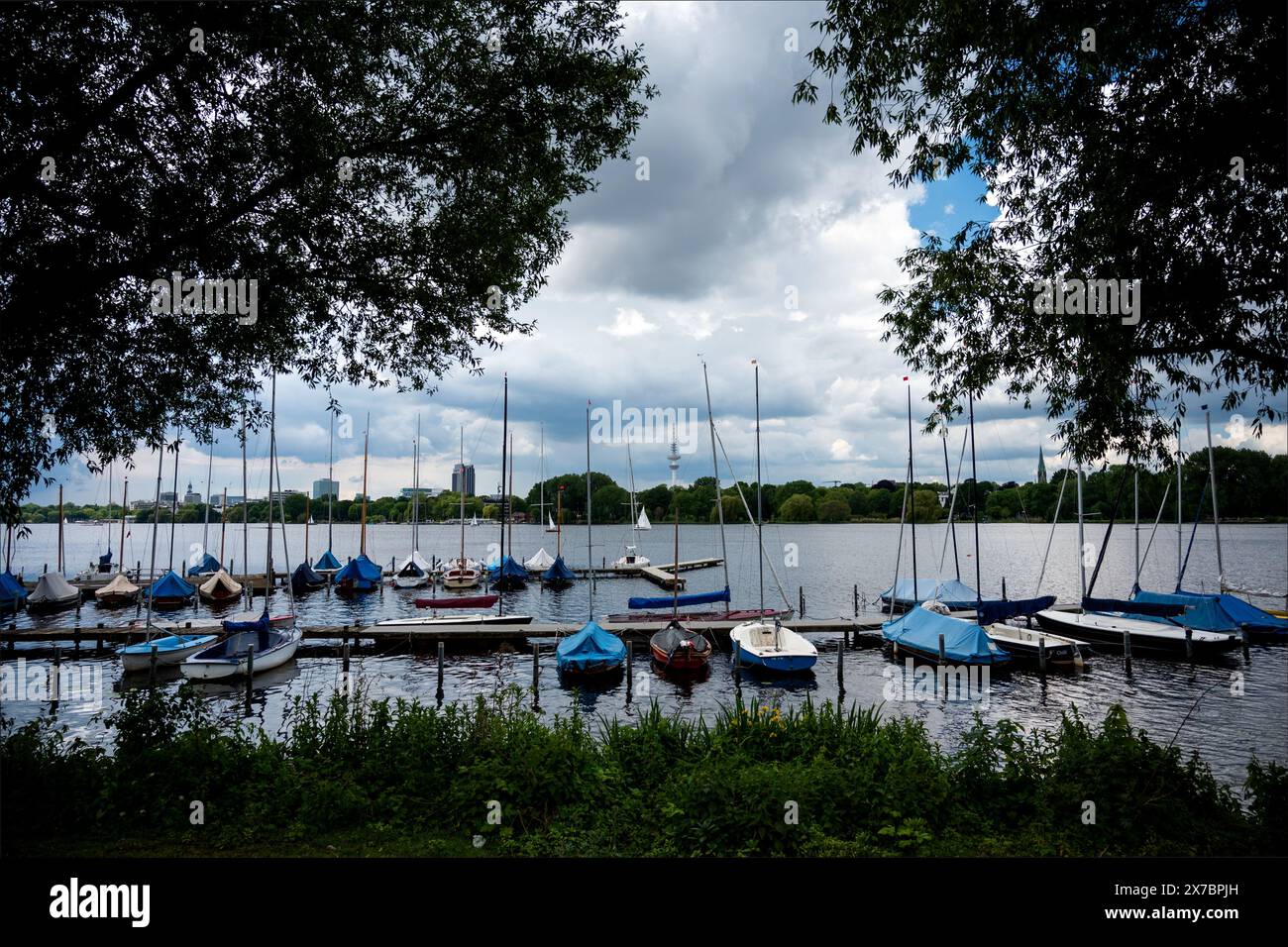19 maggio 2024, Amburgo: Le barche a remi sono ormeggiate su un molo nell'Alster esterno. Le nuvole scure si spostano sullo sfondo. Foto: Daniel Bockwoldt/dpa Foto Stock