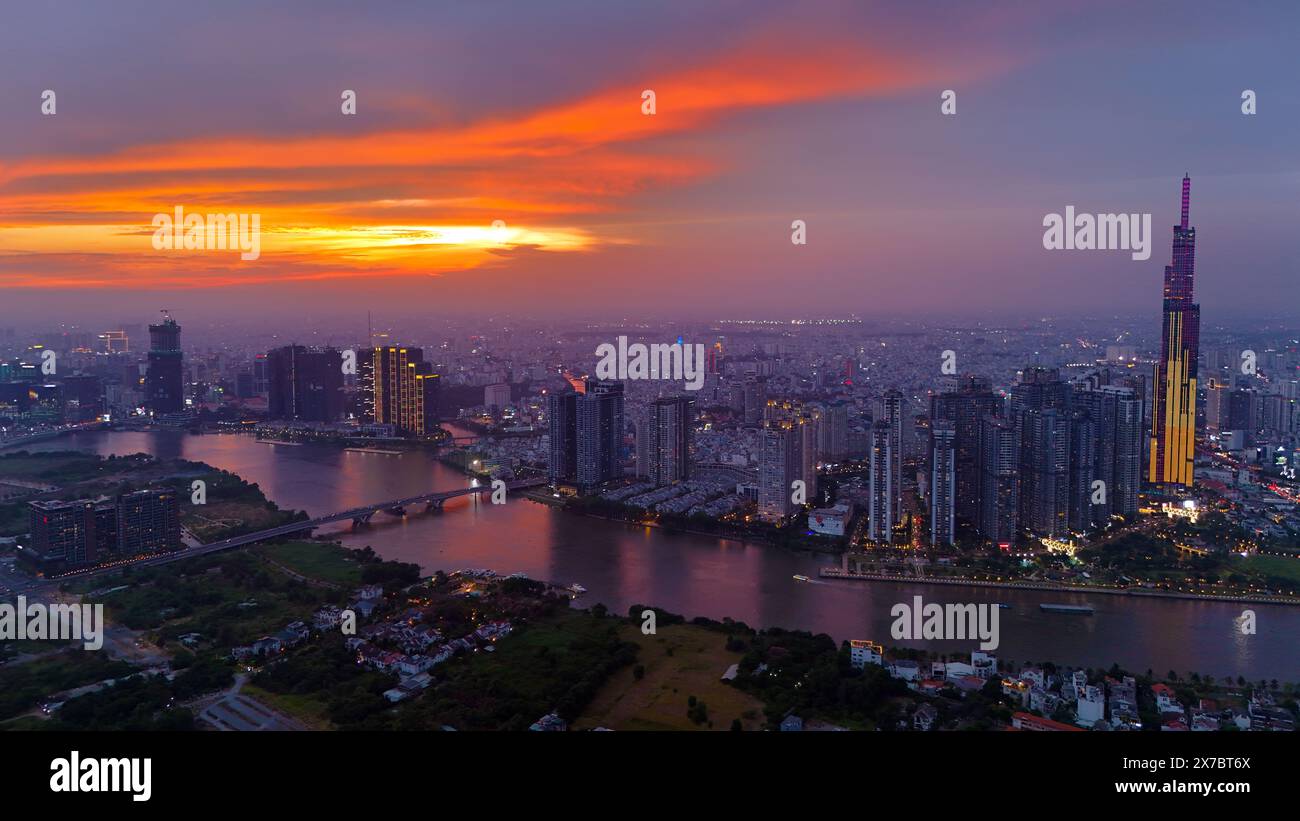 Città di ho chi Minh, Vietnam, vista aerea della città asiatica al tramonto in drone con il grattacielo Landmark 81, barca sul fiume Saigon Foto Stock