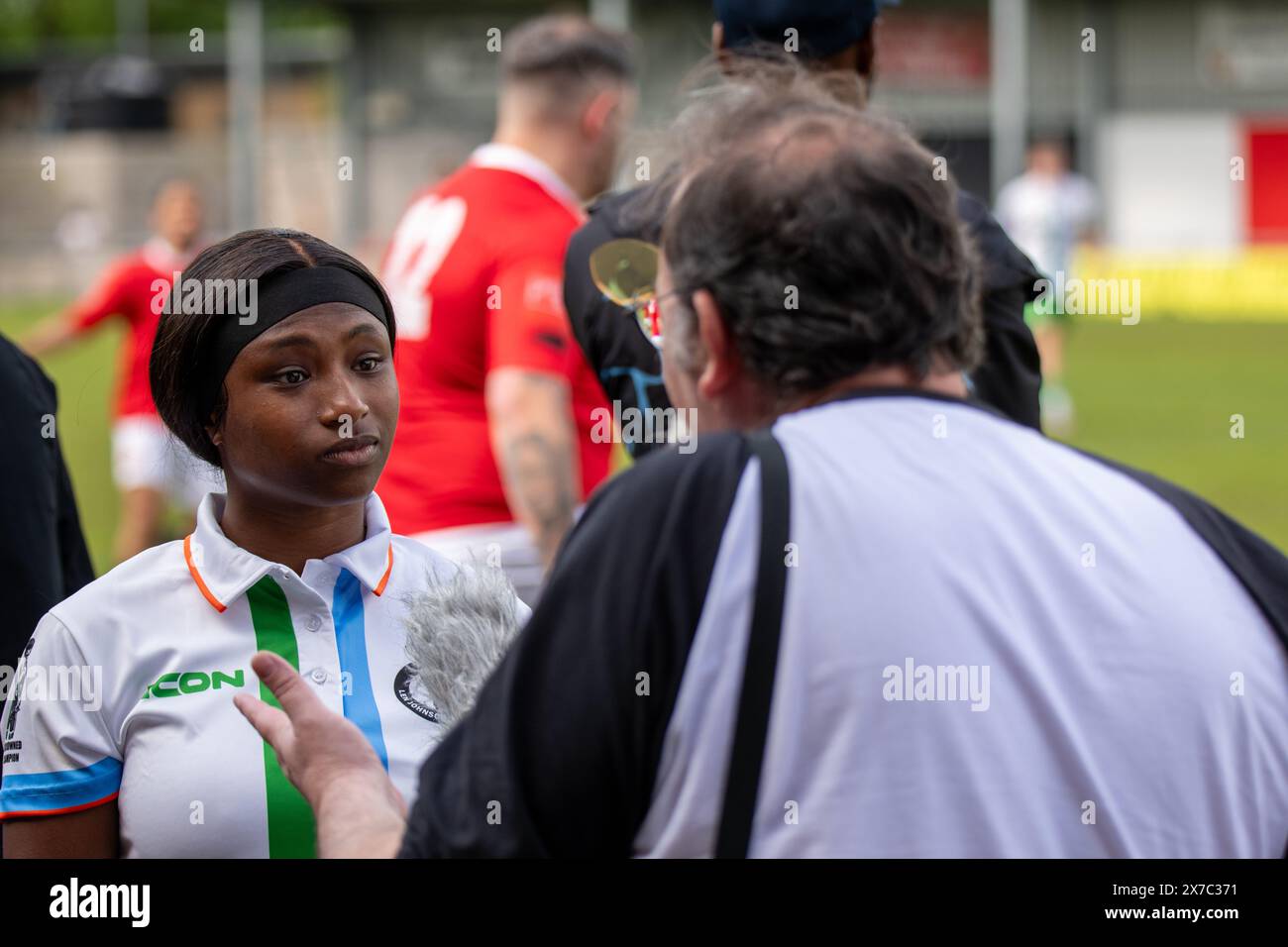 Manchester, Regno Unito. 18 maggio 2024. La rapper Lady Ice è stata intervistata dal regista Rafe Conn alla partita di football di Len Johnson contro FC United Legends al Broadhurst Park Stadium. La partita è stata organizzata per riconoscere l'ex campione di pugilato non incoronato, Len Johnson e raccogliere fondi per una statua proposta da collocare a Manchester. Alla partita parteciparono numerose celebrità come la rapper locale mancuniana Lady Ice, il popolare YouTuber Angry Ginge, l'attore Lamin Touray e l'apprendista star Kayode Damali. Picture Garyroberts/worldwidefeatures.com credito: GaryRobertsphotography/Alamy Liv Foto Stock