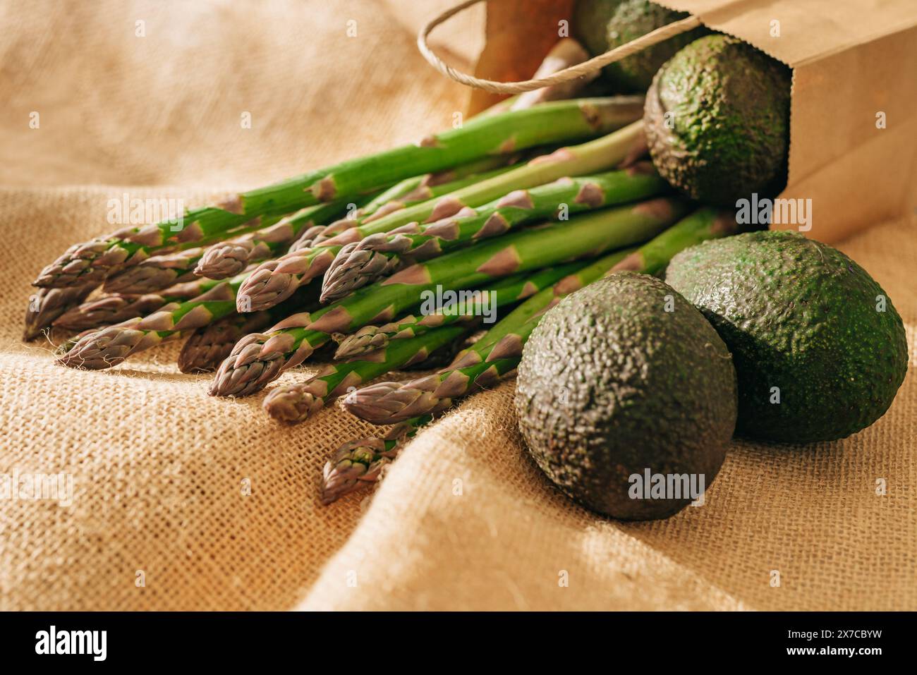 Asparagi verdi e avocado freschi in primo piano su sfondo rustico Foto Stock