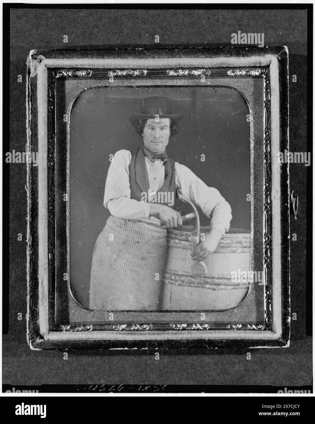 Ritratto professionale di una bottaia, lunghezza tre quarti, con barilotto e attrezzi, etichetta della didascalia della mostra "American Treasures Memory": Strumenti del mestiere. Louis-Jacques-Mandé Daguerre inventò il processo di daguerreotipo che fu poi annunciato in Francia il 19 agosto 1839. Anche se un processo complesso e lento, i fotografi americani hanno rapidamente sfruttato questa nuova invenzione grazie alla sua capacità di catturare una "somiglianza sincera". Tipicamente ritrattistica in natura, celebrità, figure politiche e commercianti erano spesso invitati e incoraggiati a fare scattare le loro foto da daguerre Foto Stock