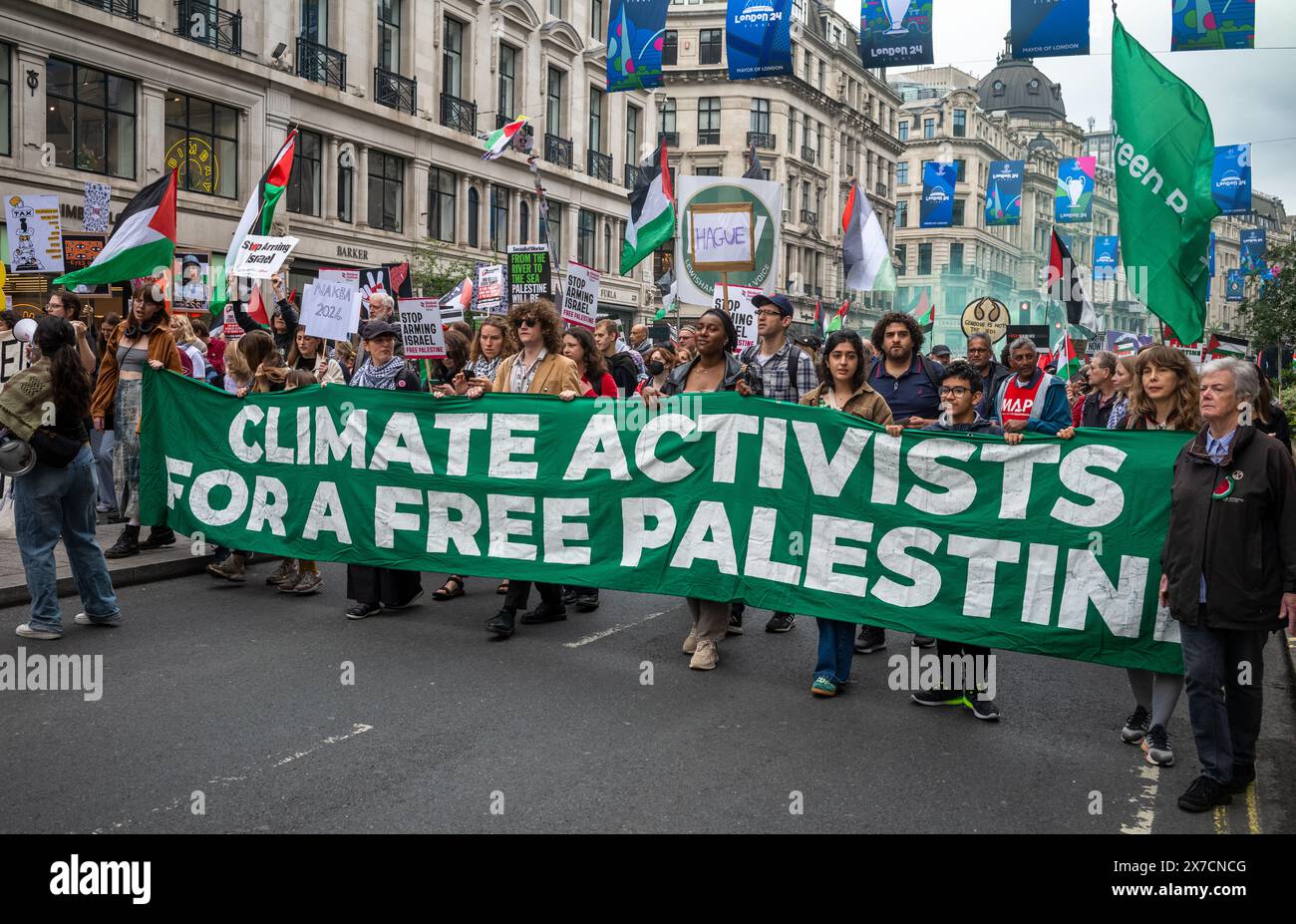 Londra, Regno Unito. 18 maggio 2024: Le attiviste climatiche marciano dietro una grande bandiera alla Nakba 76 marzo per la Palestina contro gli attacchi israeliani a Gaza nel centro Foto Stock