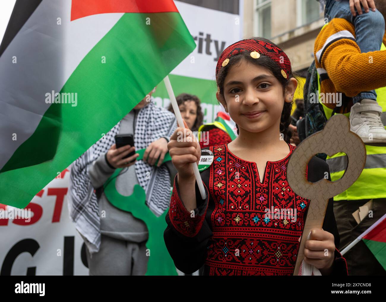 Londra, Regno Unito. 18 maggio 2024: Una giovane ragazza vestita con abiti tradizionali palestinesi tiene una "chiave palestinese" e una bandiera alla Nakba 76 marzo per Palesti Foto Stock