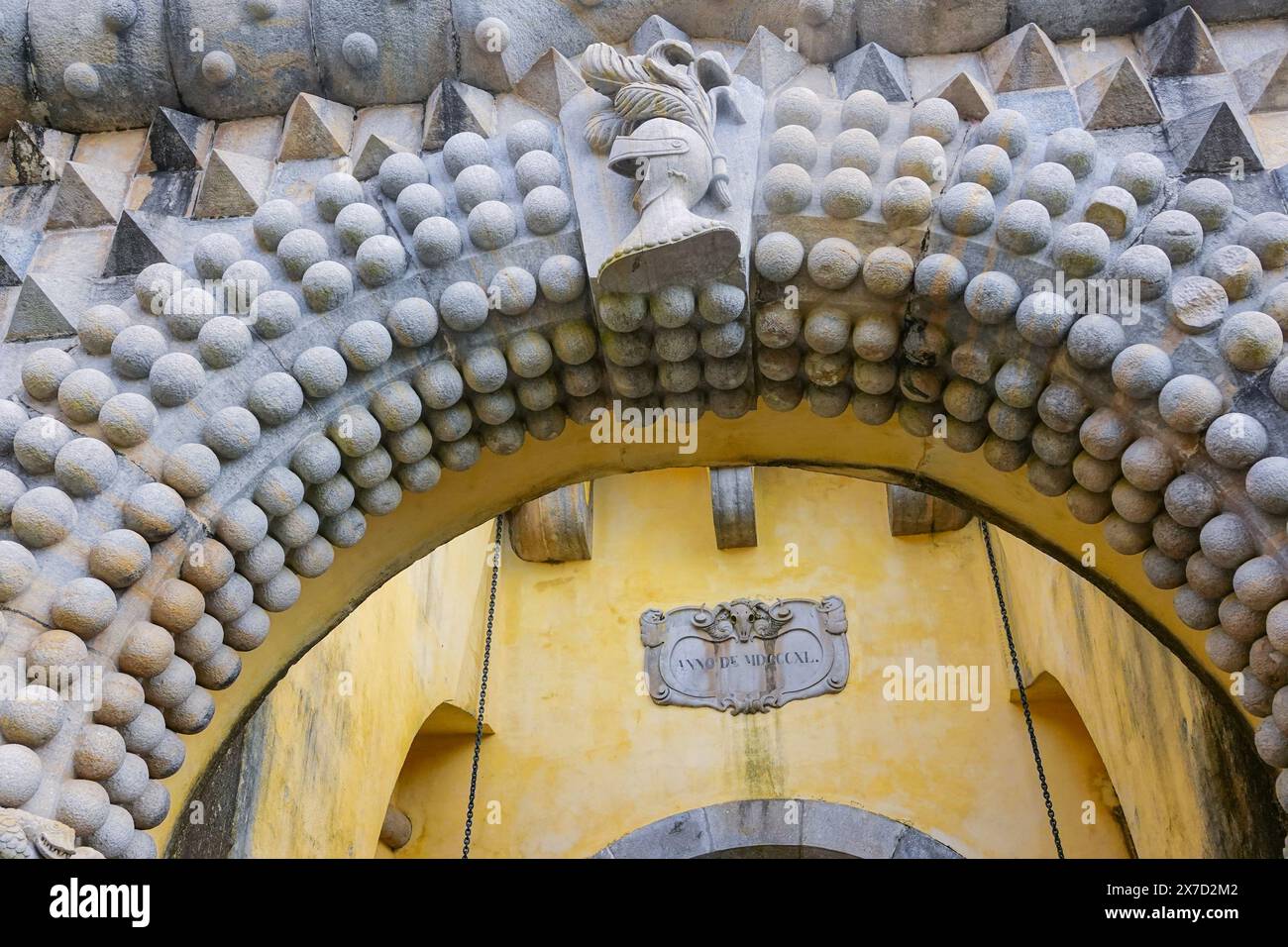 L'elmetto dei cavalieri e le palle di pietra scolpite nell'ingresso Monumentale al Palazzo pena o al castello storico di Palácio da pena, visto dal cantiere delle carrozze di Sintra, Portogallo. Il castello da favola è considerato uno dei più bei esempi di architettura romanticistica portoghese del XIX secolo al mondo. Foto Stock