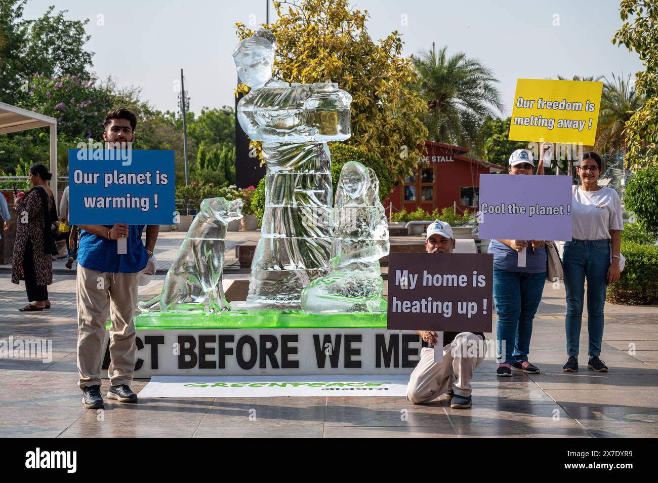 Gli attivisti di Greenpeace tengono cartelli di protesta accanto a una scultura di ghiaccio che si sta sciogliendo sotto l'ondata di caldo a Delhi, per mostrare l'impatto delle ondate di calore in tutto il paese, come parte di una protesta organizzata da un attivista di Greenpeace al Select City Mall di Saket. La scultura di ghiaccio alta 8 metri, che mostra una donna con un bambino e un cane, rappresenta alcune delle comunità più vulnerabili colpite dalle ondate di calore e da altri eventi meteorologici estremi. Mentre si scioglie nel sole di Delhi, invia un messaggio "agisci prima di scioglierci”, esortando l'Autorità nazionale per la gestione delle catastrofi a dichiarare le ondate di calore un disastro nazionale. Foto Stock