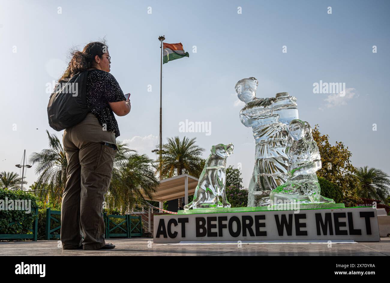 Un visitatore scatta una foto della scultura di ghiaccio, che si scioglie sotto l'onda di calore a Delhi per mostrare l'impatto delle onde di calore in tutto il paese, come parte di una protesta organizzata da un attivista di Greenpeace al Select City Mall di Saket. La scultura di ghiaccio alta 8 metri, che mostra una donna con un bambino e un cane, rappresenta alcune delle comunità più vulnerabili colpite dalle ondate di calore e da altri eventi meteorologici estremi. Mentre si scioglie nel sole di Delhi, invia un messaggio "agisci prima di scioglierci”, esortando l'Autorità nazionale per la gestione delle catastrofi a dichiarare le ondate di calore un disastro nazionale. Foto Stock