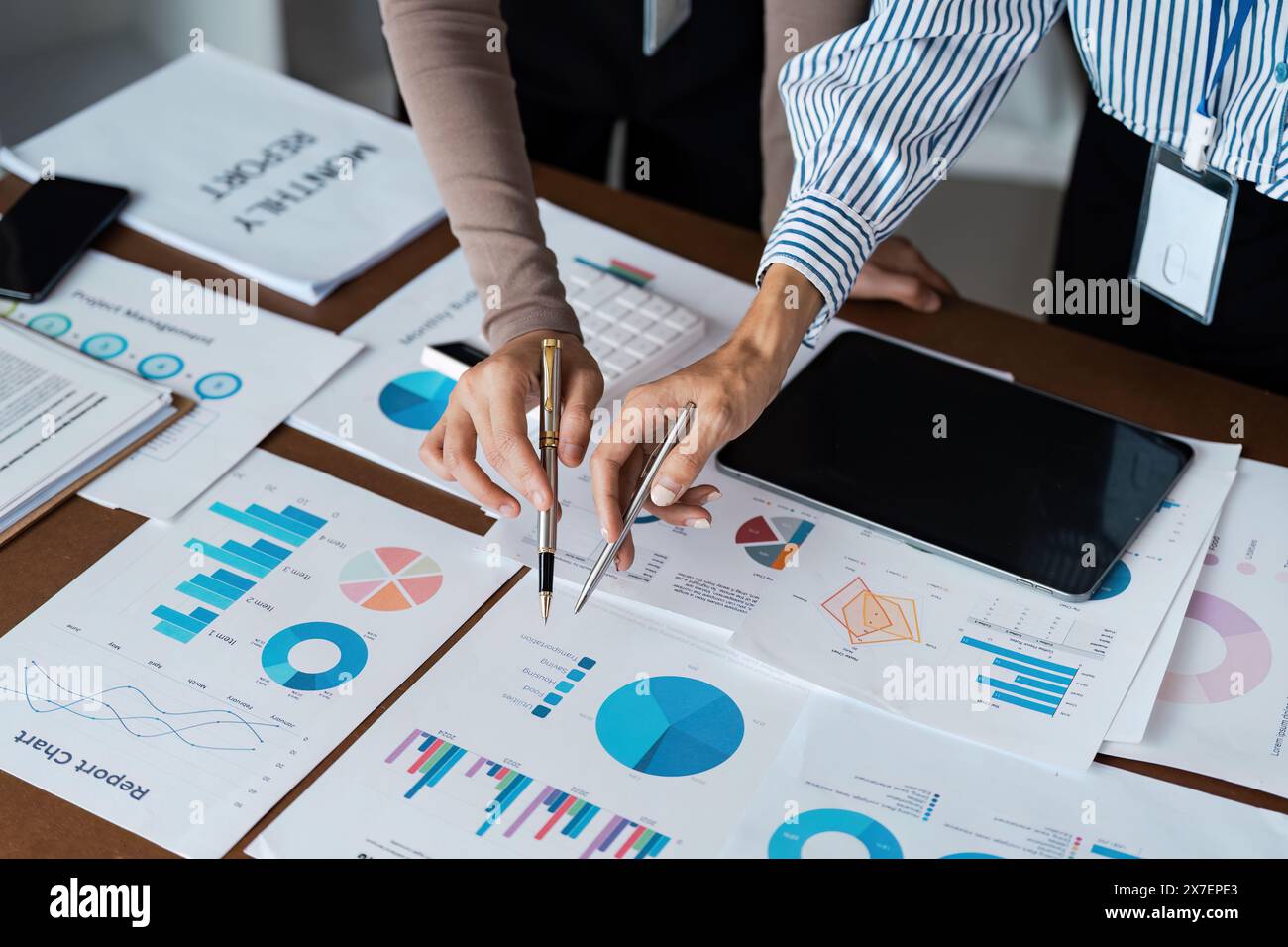 Una donna d'affari collaborativa si riunisce per analizzare grafici finanziari e grafici sulla scrivania per la pianificazione strategica Foto Stock