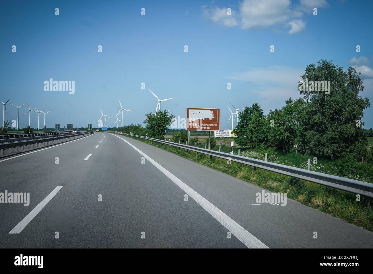 Autobahn, Straßenschild, UNESCO-Weltnaturerbe Wattenmeer, Braunes Schild, Windräder, blauer Himmel, Autobahn A31, Verkehrsschild, Auto, Fahrbahn, Leitplanke, Bäume, Deutschland, Verkehr, Sommer, Wegweiser, Emslandautobahn, Nord-Süd-Verbindung, Schnellstraße, Verkehrsnetz, 241 km da Emden, Bottrop, gebaut 1967-2004, wichtige Route Niedersachsen, Nordrhein-Westfalen, landschaftlich reizvoll, wenig befahren, schnelle Verbindungen, regionale Wirtschaft, Tourist ische Ziele, Umwelt, Naturschutz, erneuerbare energie **** Freeway, cartello, Patrimonio dell'Umanità dell'UNESCO, cartello marrone, turbine eoliche, b Foto Stock