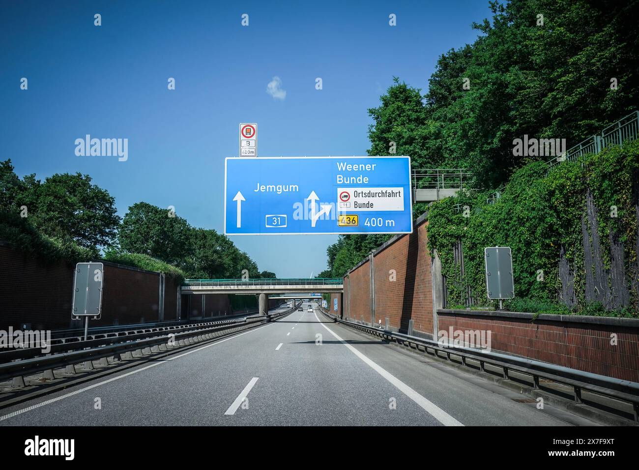 Autobahn, Straßenschild, Jemgum, Weener, Bunde, Ausfahrt, Ortsdurchfahrt, Himmel, Autobahn A31, Ausfahrt 436, 400 m, Verkehrsschild, Tunnel, Brücke, Auto, Fahrbahn, Leitplanke, Bäume, Pflanzen, Deutschland, Verkehr, Sommer, Wegweiser, Emslandautobahn, Nord-Süd-Verbindung, Schnellstraße, Verkehrsnetz, 241 km, Emden, Bottrop gebaut 1967-2004, wichtige Route, Niedersachsen, Nordrhein-Westfalen, landschaftlich reizvoll, wenig befahren, schnelle Verbindungen, regionale Wirtschaft, Tourist ische Ziele, Verkehrslenkung *** Highway, cartello stradale, Jemgum, Weener, Bunde, uscita, attraverso la strada, il cielo, l'autostrada A3 Foto Stock