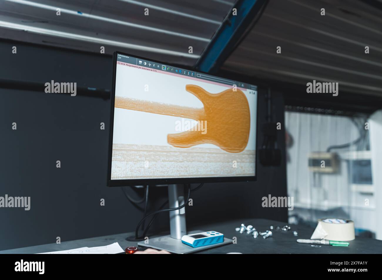 controllare la qualità di una chitarra sullo schermo del computer, lavorando nella fabbrica di chitarre. Foto di alta qualità Foto Stock