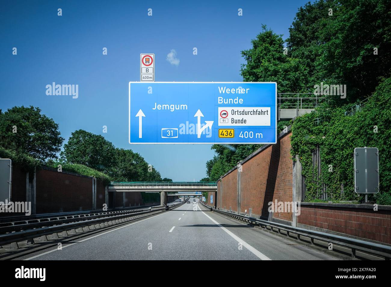 Autobahn, Straßenschild, Jemgum, Weener, Bunde, Ausfahrt, Ortsdurchfahrt, Himmel, Autobahn A31, Ausfahrt 436, 400 m, Verkehrsschild, Tunnel, Brücke, Auto, Fahrbahn, Leitplanke, Bäume, Pflanzen, Deutschland, Verkehr, Sommer, Wegweiser, Emslandautobahn, Nord-Süd-Verbindung, Schnellstraße, Verkehrsnetz, 241 km, Emden, Bottrop gebaut 1967-2004, wichtige Route, Niedersachsen, Nordrhein-Westfalen, landschaftlich reizvoll, wenig befahren, schnelle Verbindungen, regionale Wirtschaft, Tourist ische Ziele, Verkehrslenkung *** Highway, cartello stradale, Jemgum, Weener, Bunde, uscita, attraverso la strada, il cielo, l'autostrada A3 Foto Stock