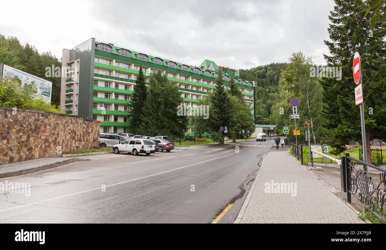 Belokurikha, Russia - 19 agosto 2022: Vista sulla strada del resort Belokurikha con edifici del sanatorio Katun. La gente cammina per la strada vicino alle auto parcheggiate Foto Stock