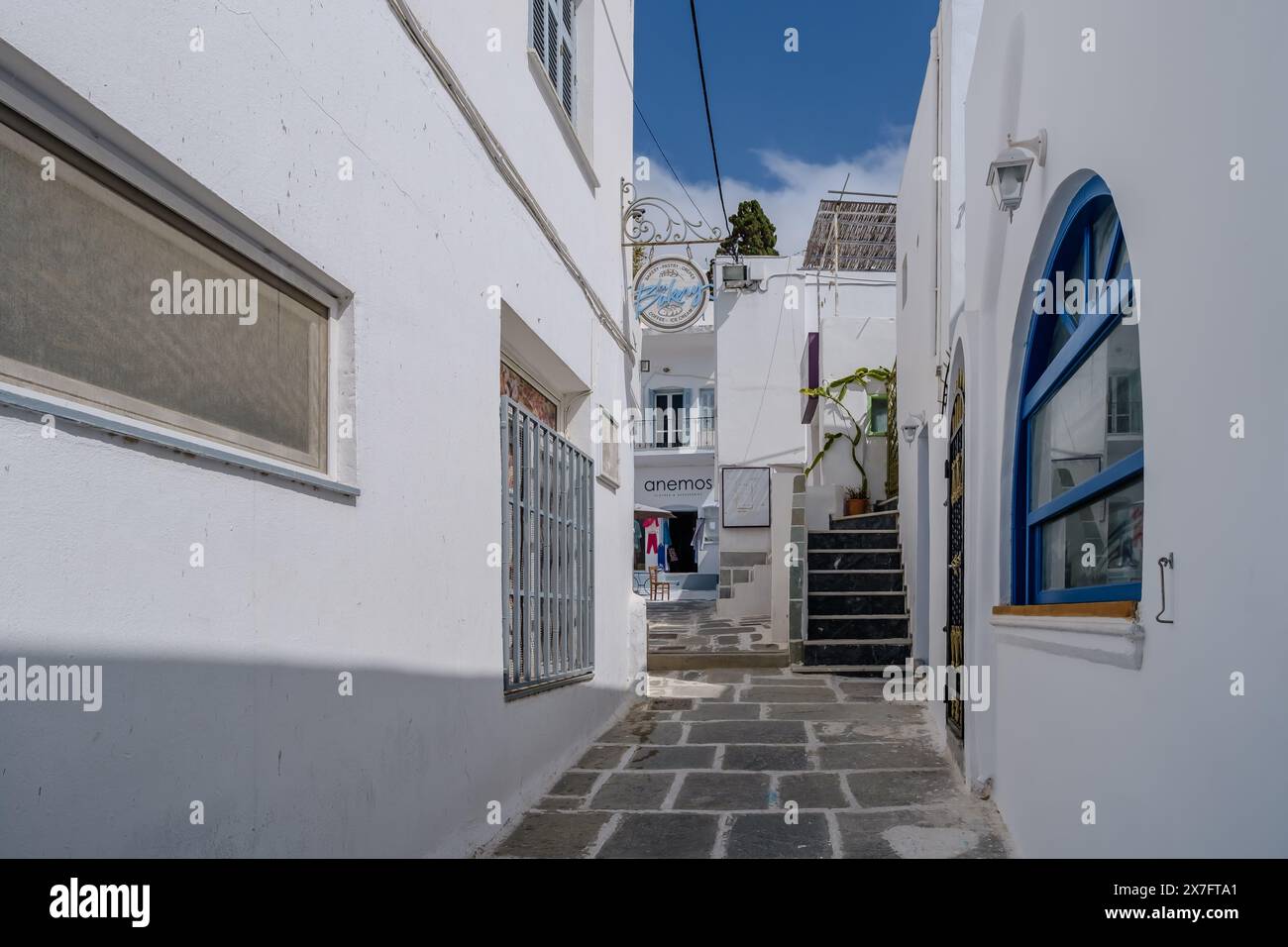 IOS, Grecia - 1 maggio 2024: Vista di vari pittoreschi negozi e ristoranti imbiancati nel villaggio di iOS Grecia Foto Stock