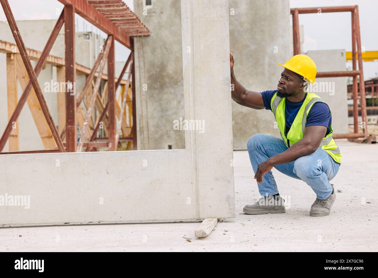 Progettazione del controllo di qualità nella produzione di colata di calcestruzzo prefabbricato controllo di qualità dei prodotti in cantiere all'aperto, lavoratore nero africano Foto Stock