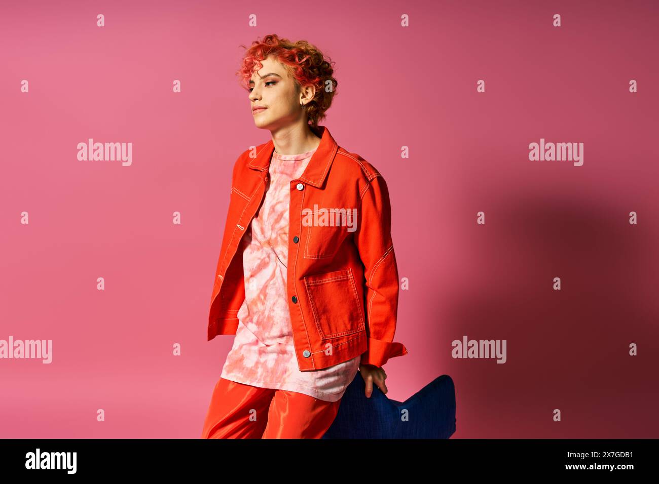 Una donna con i capelli rossi in posa su uno sfondo vibrante. Foto Stock