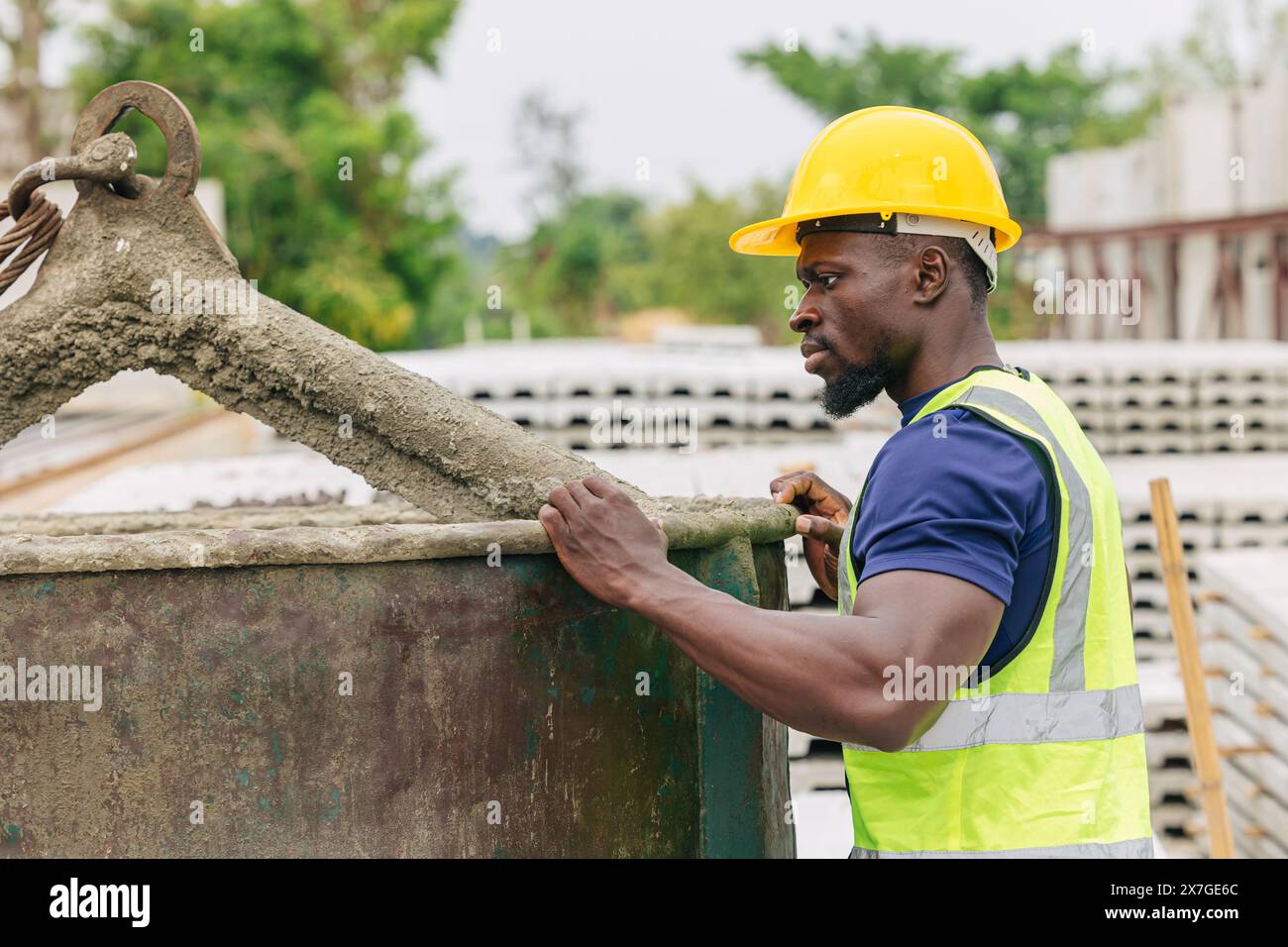 Progettazione del controllo di qualità nella produzione di colata di calcestruzzo prefabbricato controllo di qualità dei prodotti in cantiere all'aperto, lavoratore nero africano Foto Stock