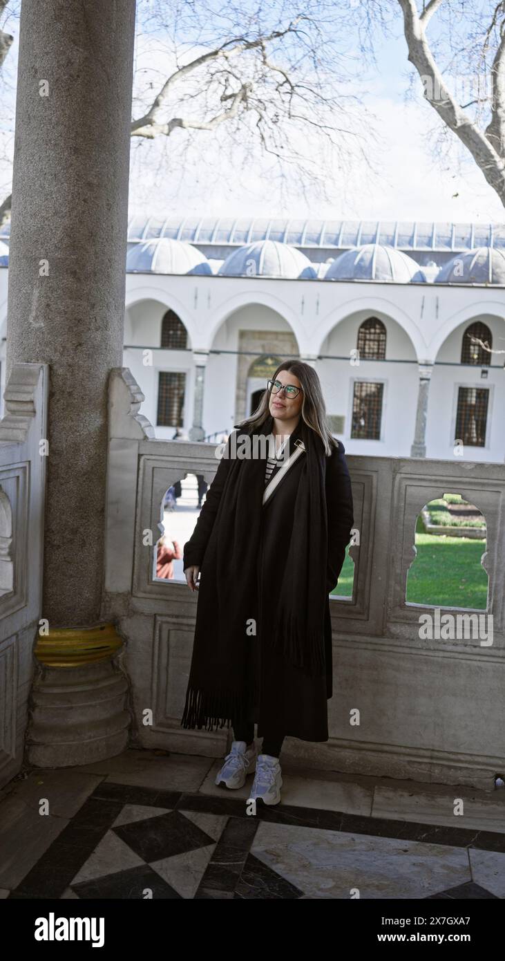 Donna sorridente in un abbigliamento casual che esplora lo storico palazzo topkapi a istanbul, turchia. Foto Stock