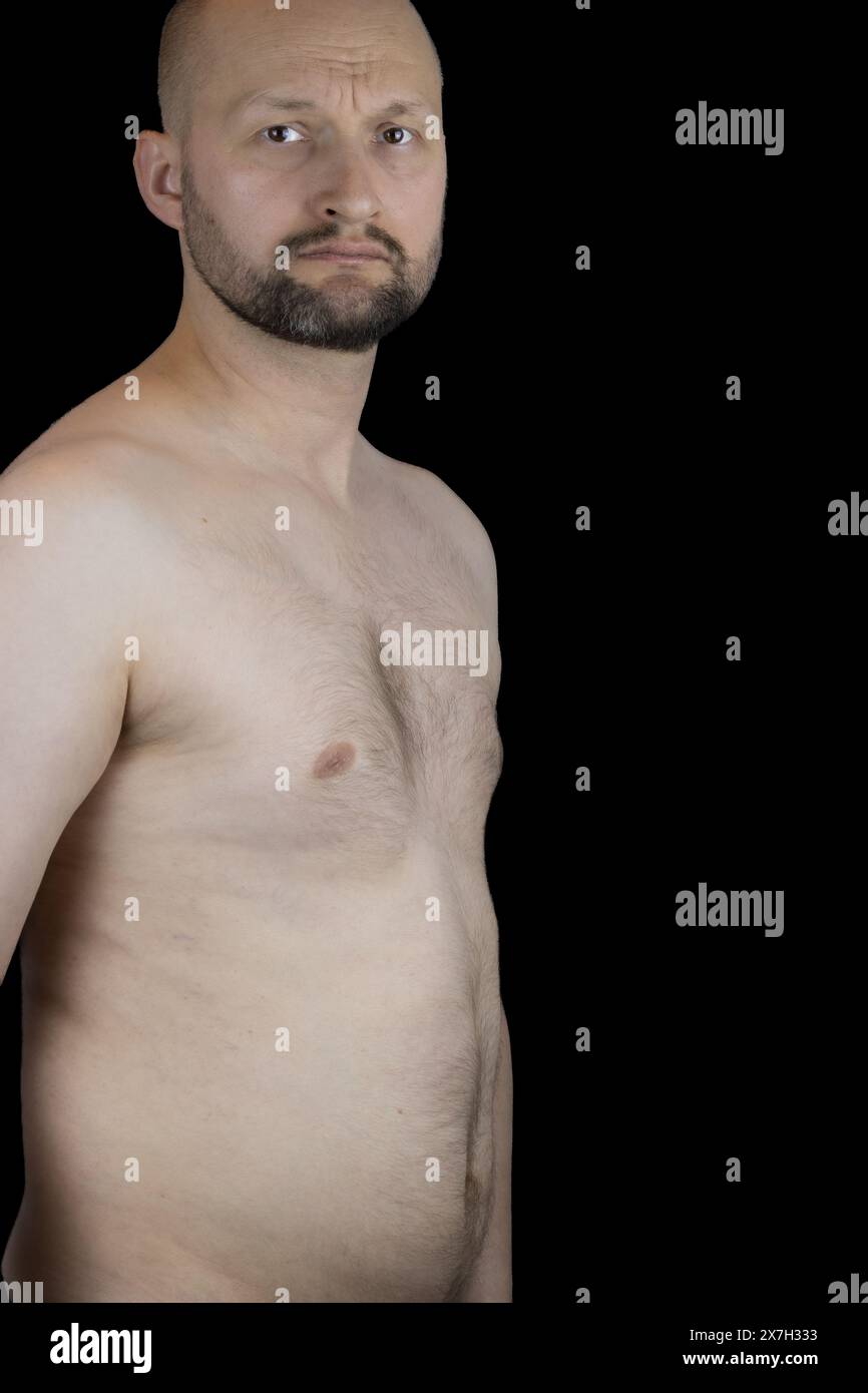 Questo ritratto cattura la presenza dignitosa di un uomo di 45 anni su uno sfondo nero. Foto Stock