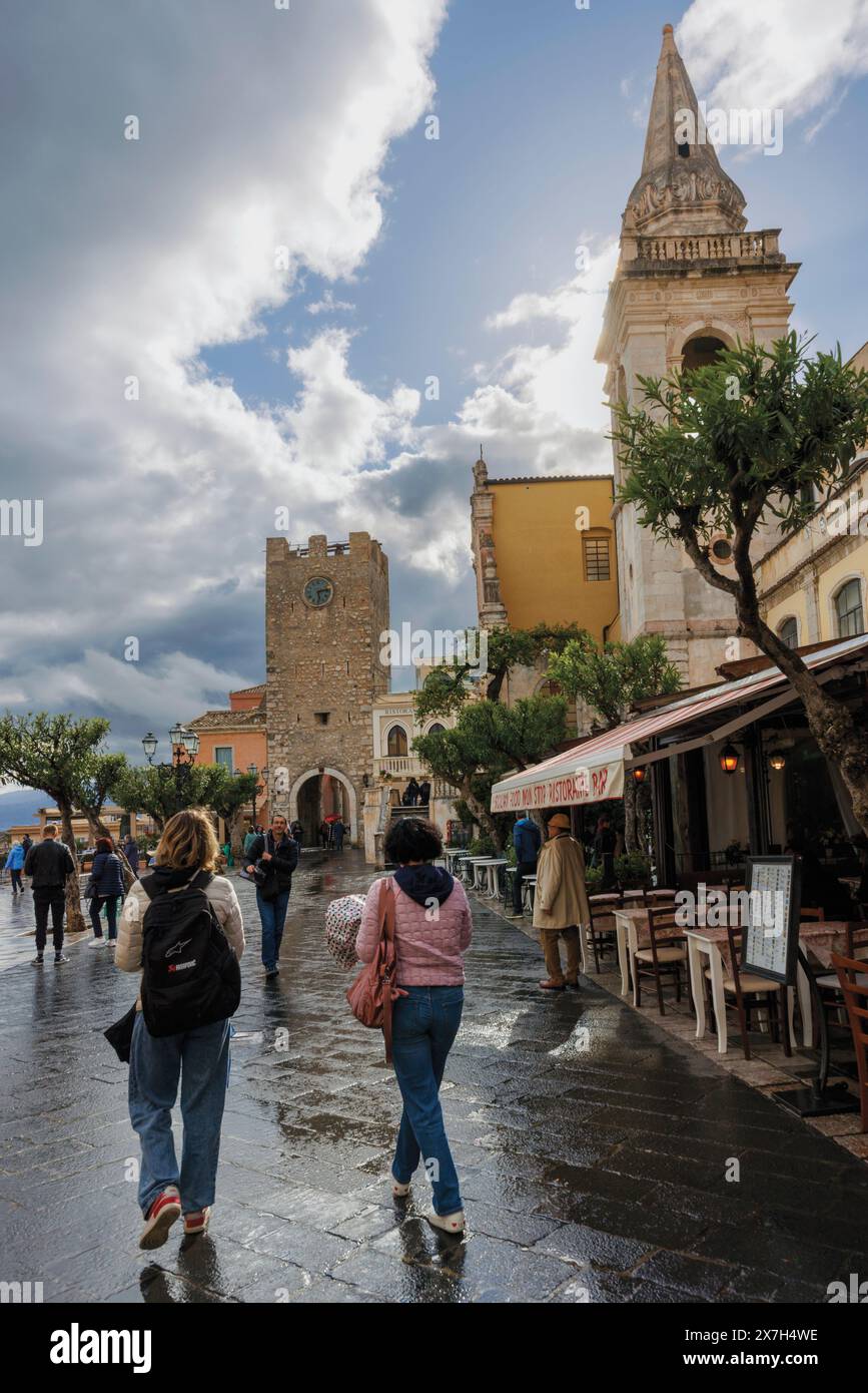 Taormina, Sicilia, Italia. Piazza IX aprile in un giorno di pioggia. Chiesa di San Giuseppe, Torre dell'Orologio. Porta dell'Orologio; Foto Stock