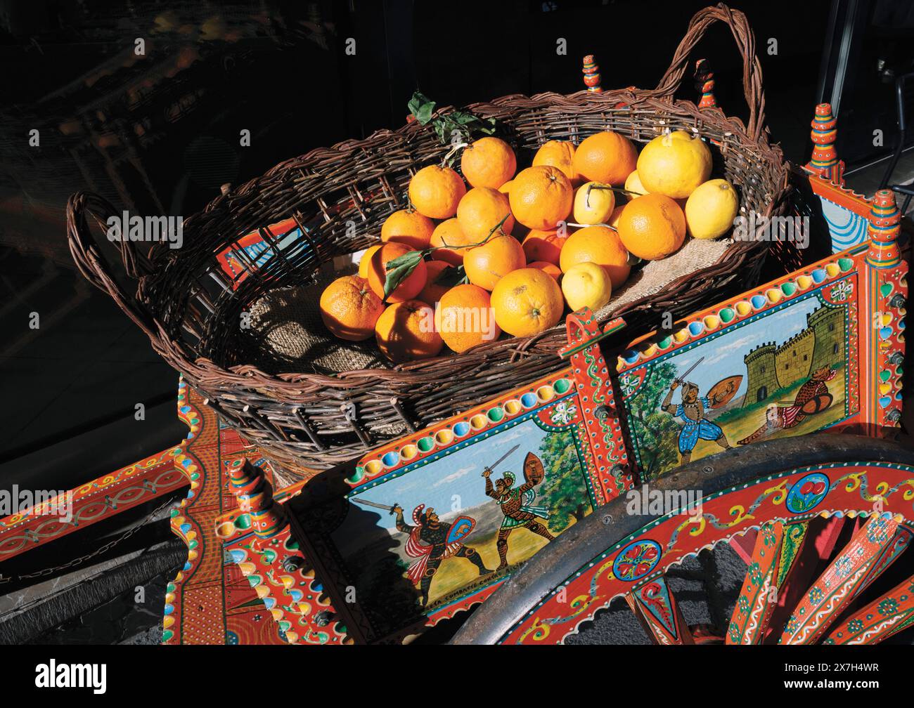 Taormina, Sicilia, Italia. Carretto Siciliano o Carretto Siciliano, con scene di combattimenti di cavalieri. Ora vendeva arance e limoni. Foto Stock