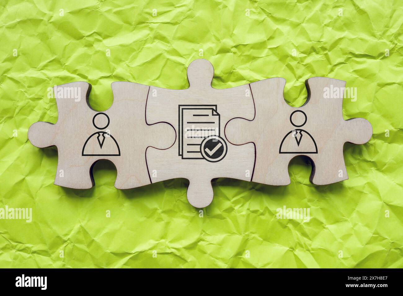 Elementi puzzle con figure e un contratto come simbolo di comprensione e accordo. Foto Stock