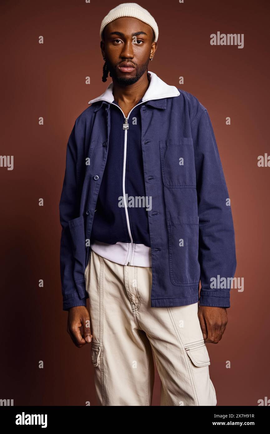 Un bel giovane afroamericano con giacca blu e pantaloni abbronzati. Foto Stock