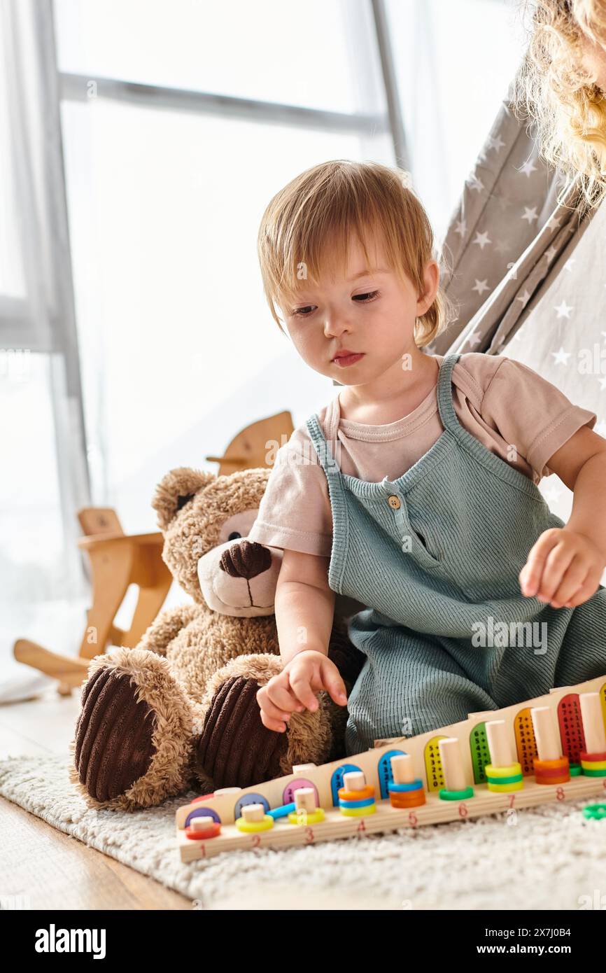 Il bambino giocherà felicemente con un trenino giocattolo, esplorando le meraviglie dell'infanzia e promuovendo la creatività con l'educazione Montessori. Foto Stock