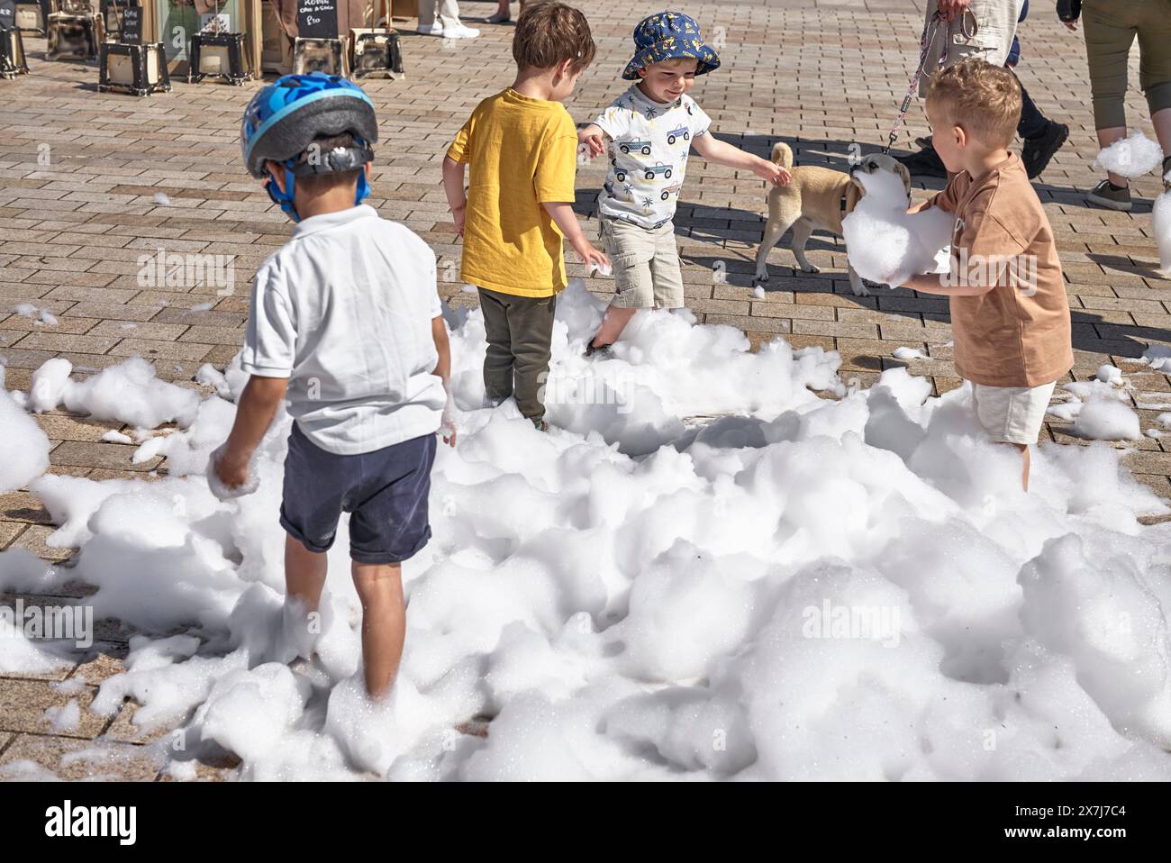 Bambini che giocano in bolle di schiuma all'aperto. Stratford Upon Avon, Inghilterra, Regno Unito. I bambini si divertono all'aperto Foto Stock