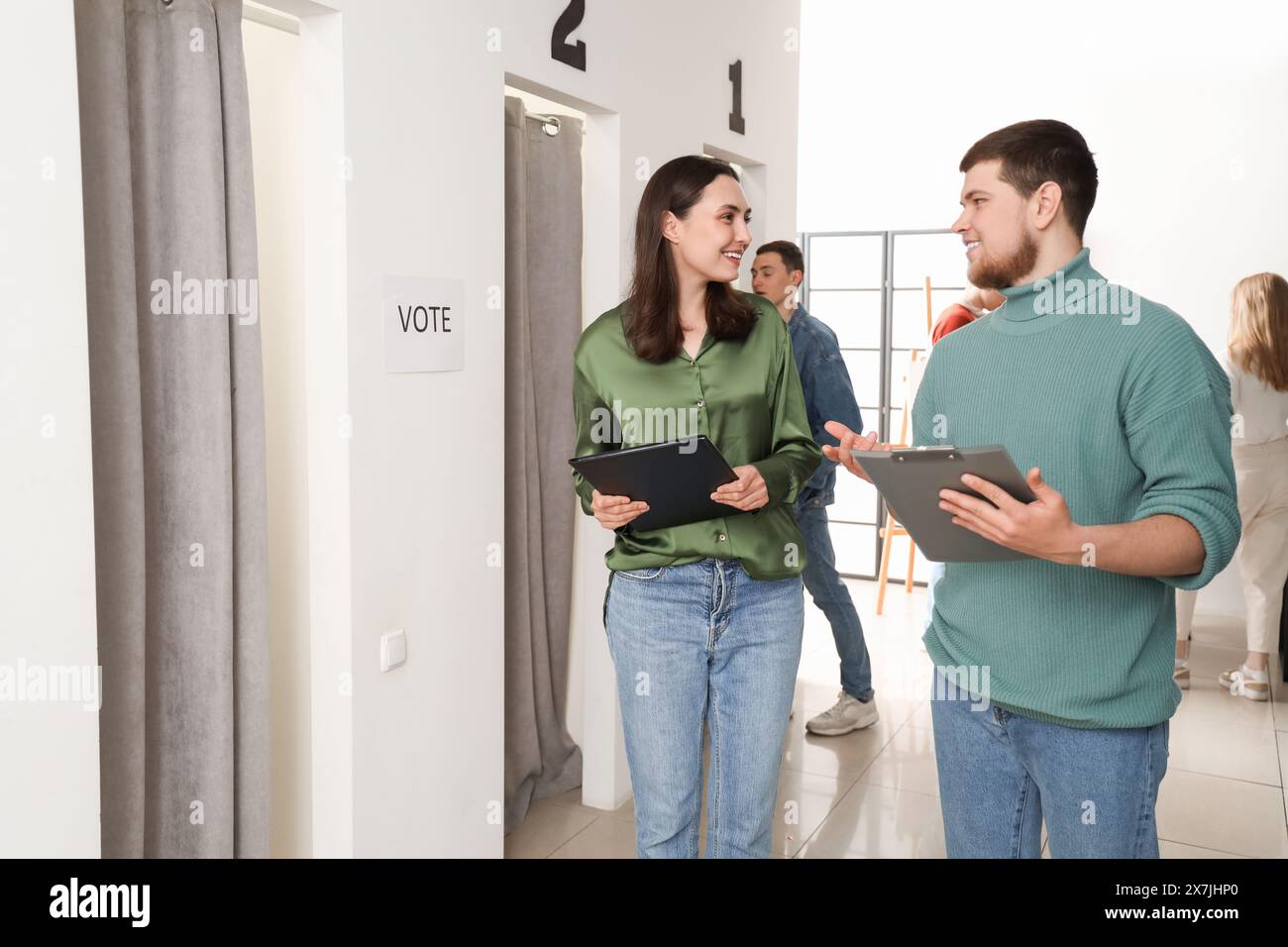 Lavoratori elettorali con appunti al seggio elettorale Foto Stock