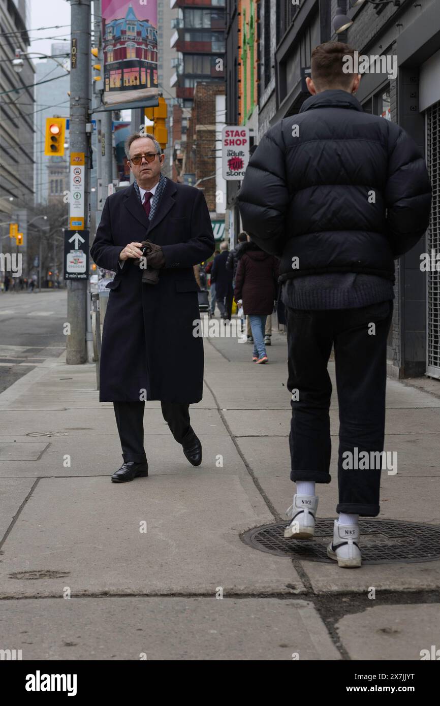 Uomo d'affari che cammina lungo la strada, Toronto, Ontario, Canada Foto Stock