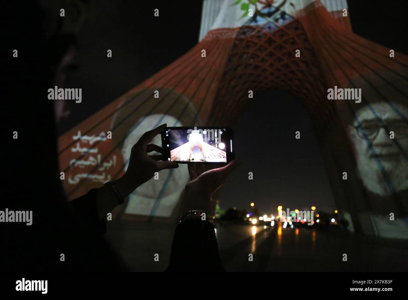 Teheran, Iran. 20 maggio 2024. Una donna iraniana scatta una foto di un video mapping del defunto progetto del presidente iraniano Ebrahim Raisi sulla torre Azadi (libertà) nella parte occidentale di Teheran. Il presidente iraniano Raisi, il ministro degli Esteri Amir-Abdollahian e altri sono morti in un incidente in elicottero il 19 maggio 2024, dopo una visita ufficiale vicino al confine con l'Azerbaigian. Il governo iraniano ha confermato le morti e ha annunciato cinque giorni di lutto pubblico. (Credit Image: © Rouzbeh Fouladi/ZUMA Press Wire) SOLO PER USO EDITORIALE! Non per USO commerciale! Foto Stock