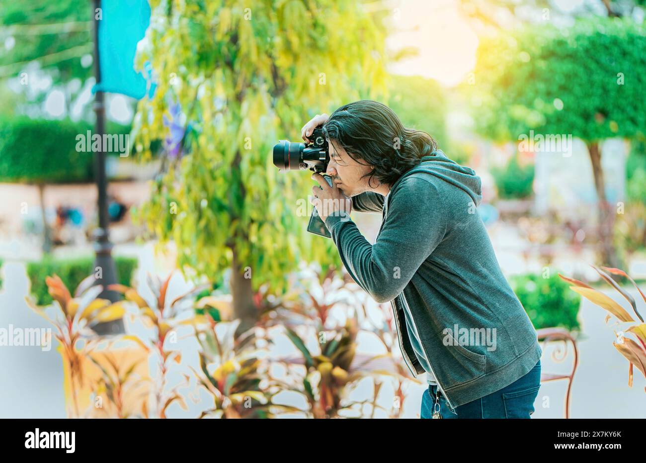 Fotografo maschile che scatta foto in un parco pubblico, Nagarote. Fotografo che scatta foto per strada Foto Stock