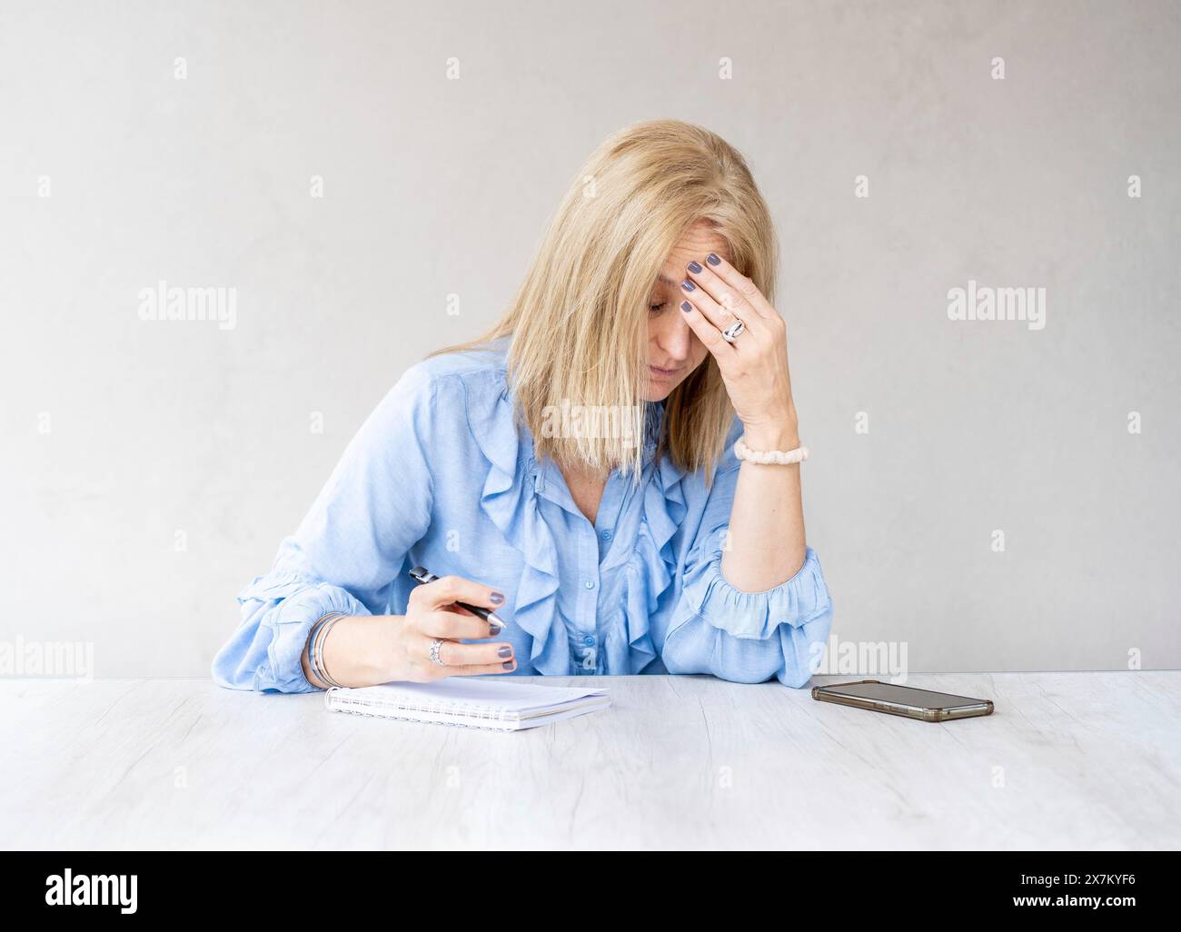 Donna stanca che tocca la fronte con mal di testa emicrania Foto Stock