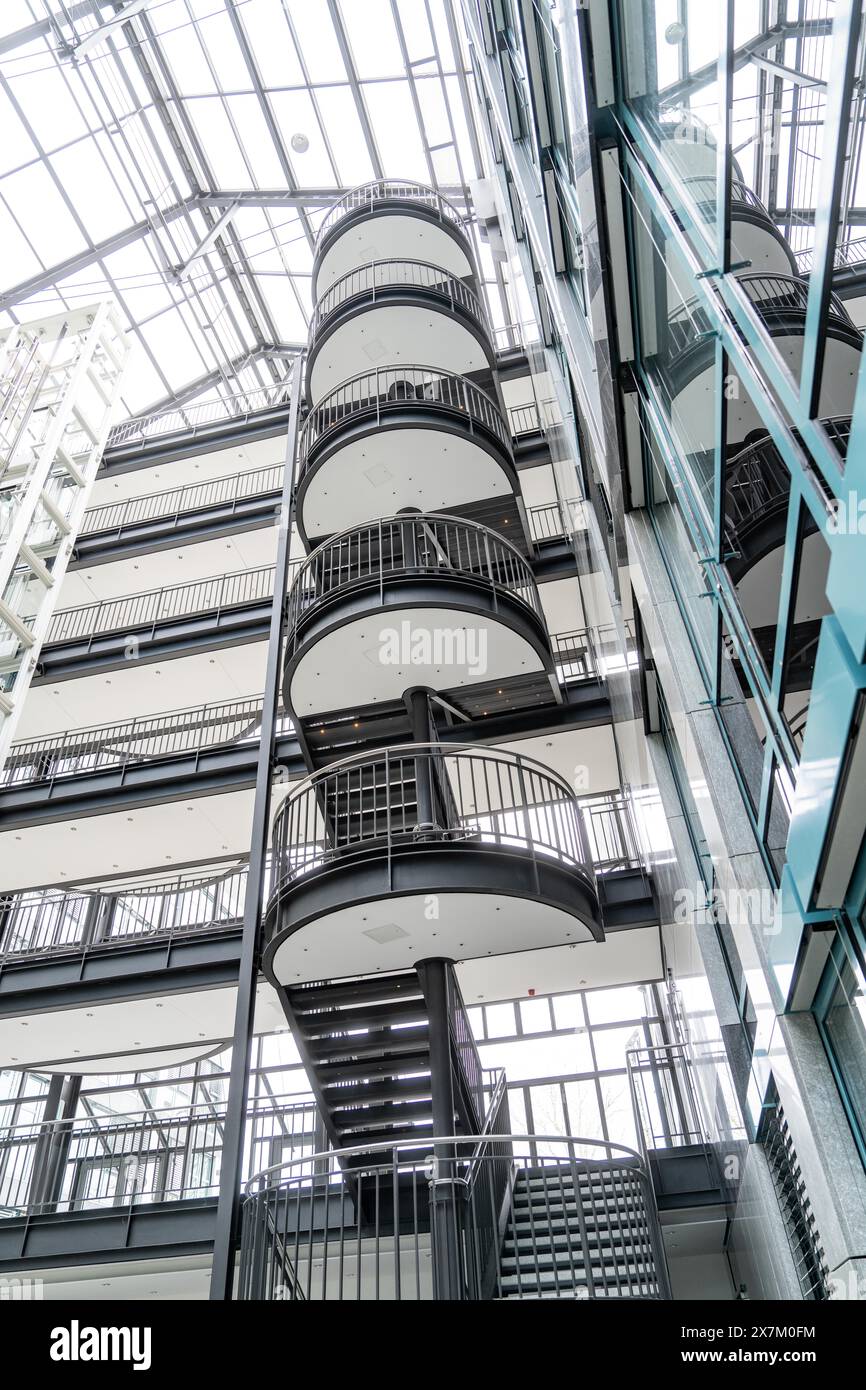 Vista interna di un moderno edificio di uffici con scala e balconi sotto un tetto di vetro, Boeblingen, Germania Foto Stock