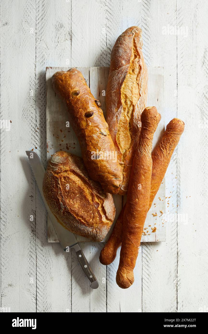 Vari tipi di pane bianco francese, baguette, petit pan su sfondo di legno bianco Foto Stock