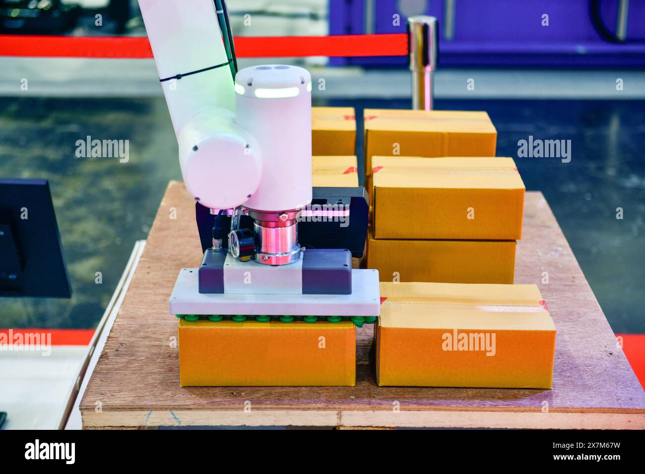 Robot industriale con scatola che aziona una macchina robotizzata a magazzino per il trasporto Foto Stock