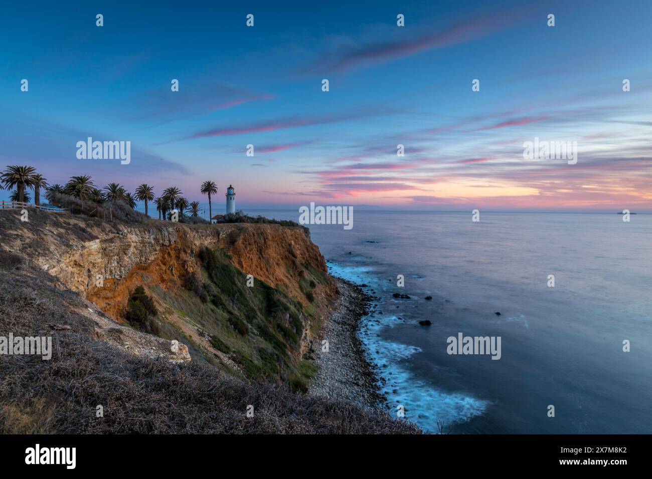 Il tranquillo tramonto dipinge il cielo sopra Point Vicente, con sfumature dorate sulla costa frastagliata, un momento sereno a Rancho Palos Verdes, California. Foto Stock