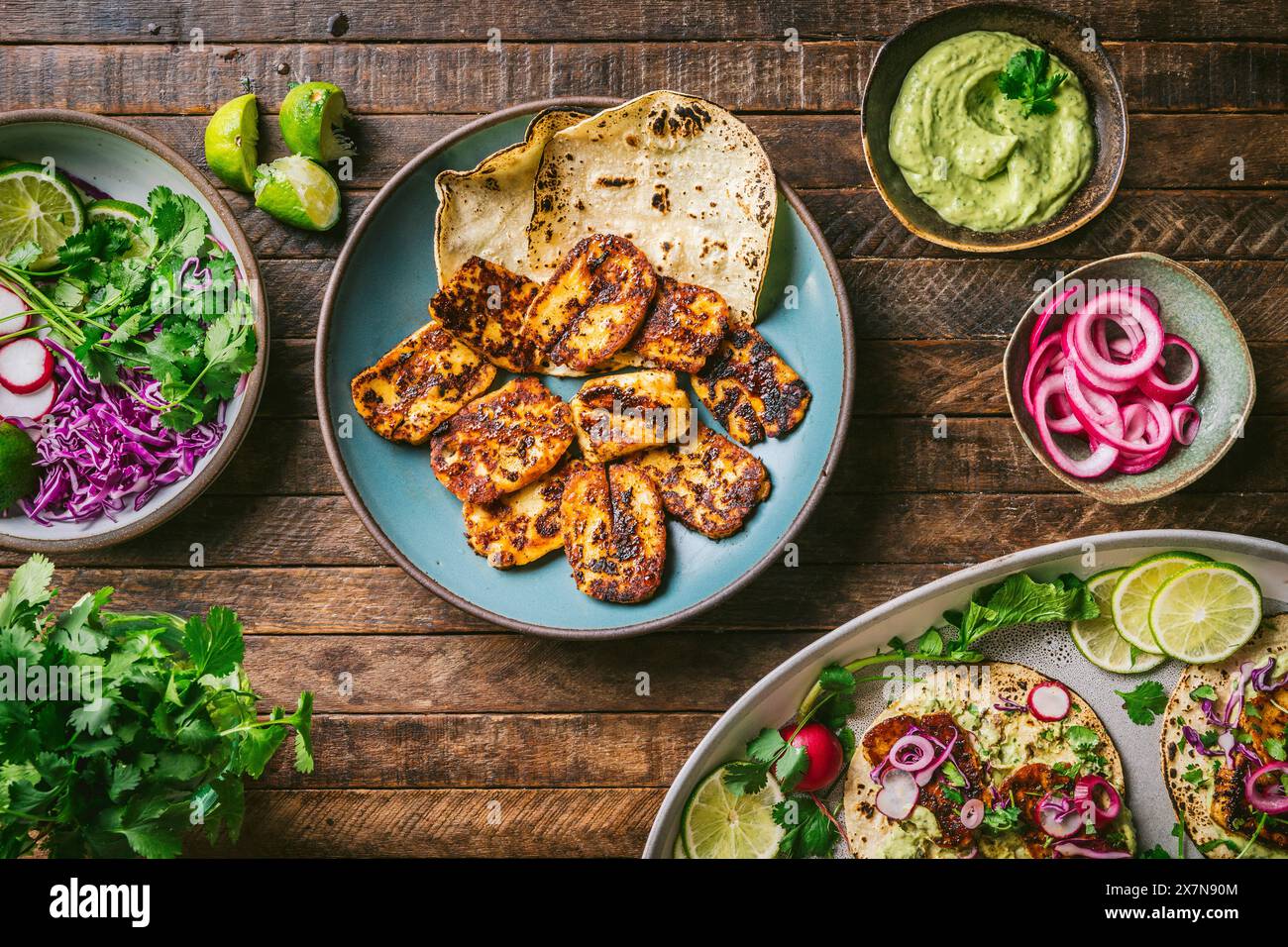 Piatto di formaggio Halloumi fritto oan, con decorazioni colorate in ciotole e piatto di tacos assemblati Foto Stock