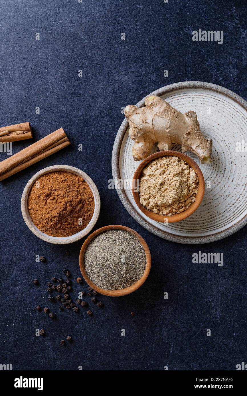 Ingredienti crudi con le loro spezie macinate appiattiscono onb su sfondo blu Foto Stock