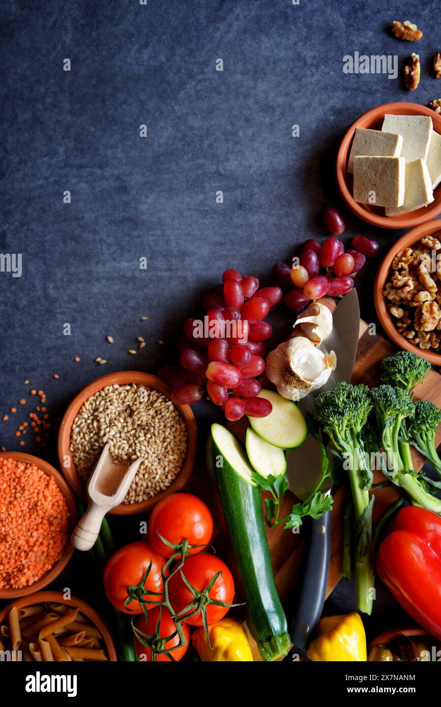 Ingredienti crudi della dieta alimentare completa a base vegetale, tra cui frutta, verdura, cereali, legumi, tofu e noci. Foto Stock