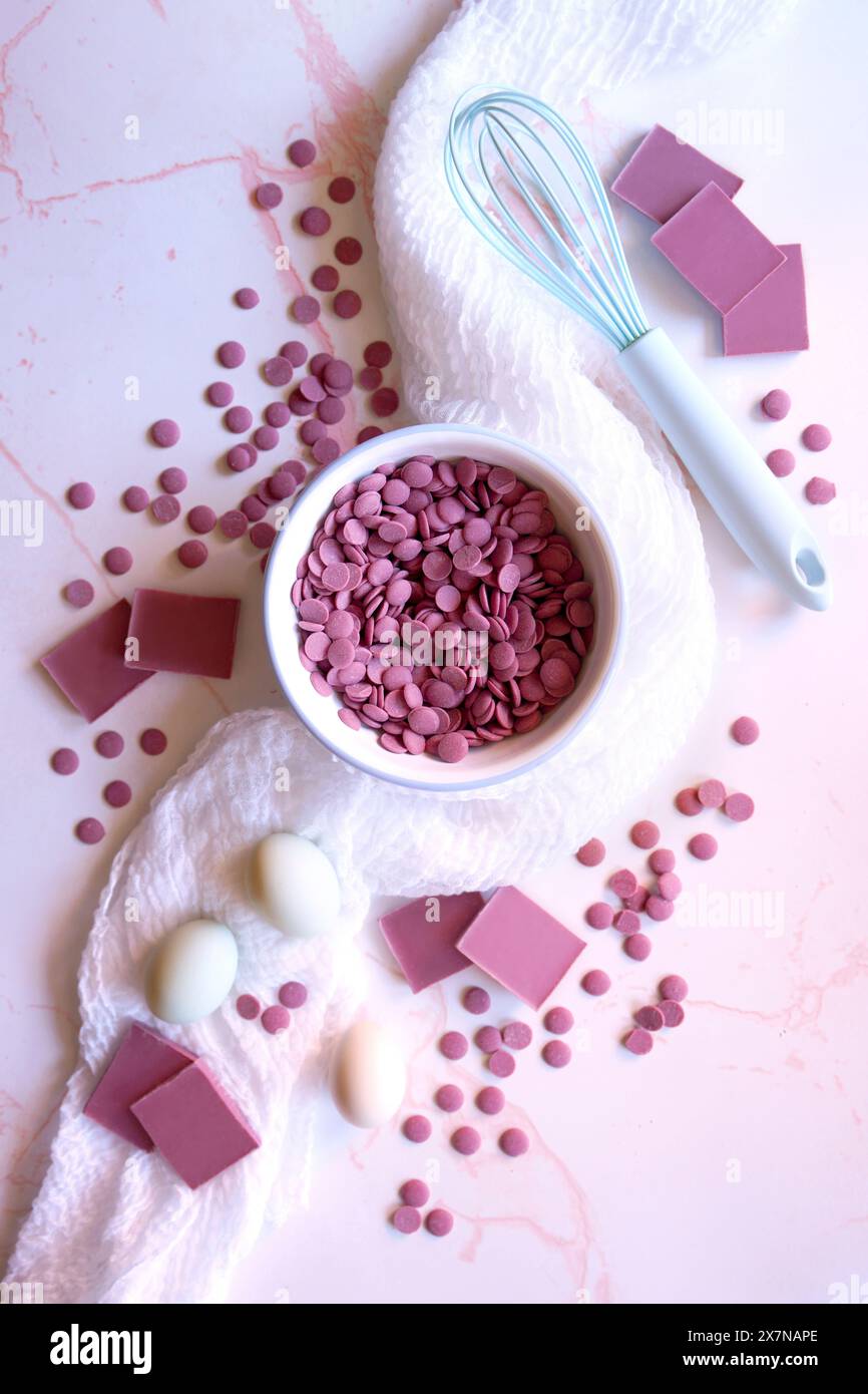 Cioccolato rubino ottenuto da varietà selezionate di fagioli botanici di cacao. Concetto di cucina con bottoni callet e pezzi di cioccolato. Foto Stock