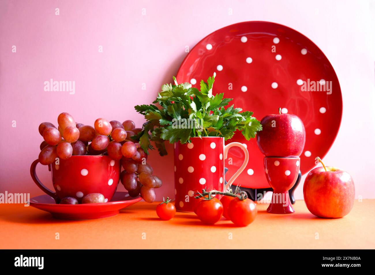 Frutta e verdura rossa con stoviglie a pois rossi, estetica che blocca il colore. Gli alimenti rossi contengono potenti antiossidanti sani, licopene, antociano Foto Stock