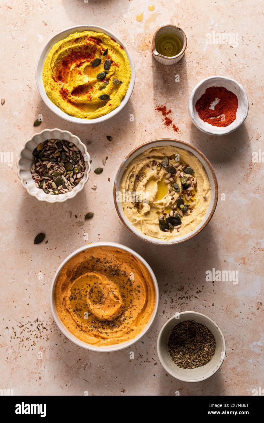 Ciotole di hummus fresco con semi, origano, paprika Foto Stock
