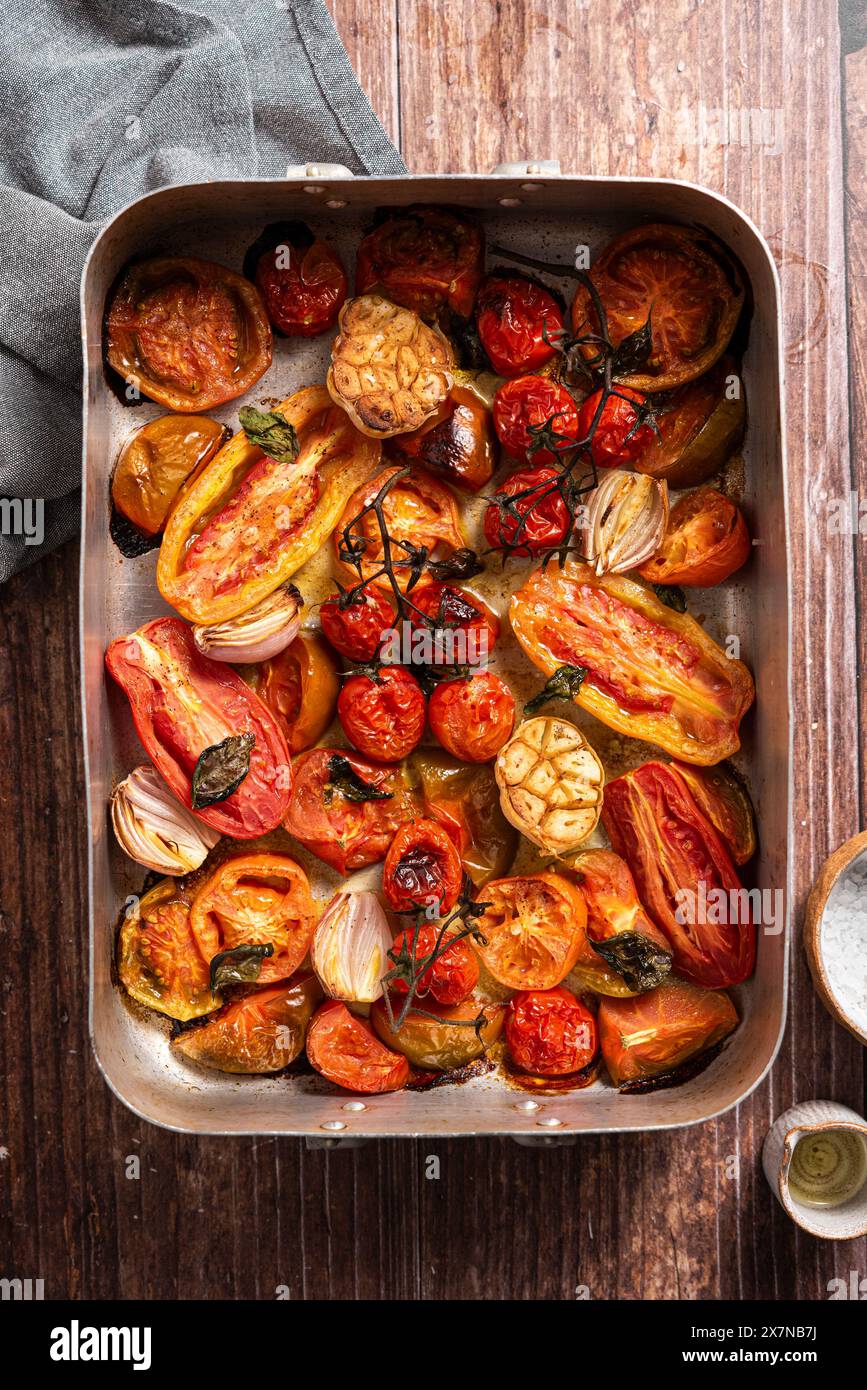 Pomodori freschi al forno, aglio, scalogno, basilico Foto Stock